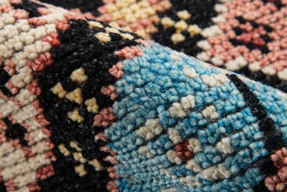 Boho geometric rug in turquoise blue with black, cream and coral accents; chunky tufted pile for cozy floor decor.