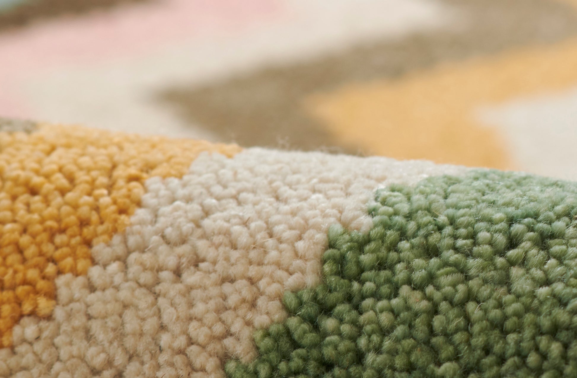 Close-up of a chunky loop rug in mustard yellow, cream and sage green; soft, textured home decor.