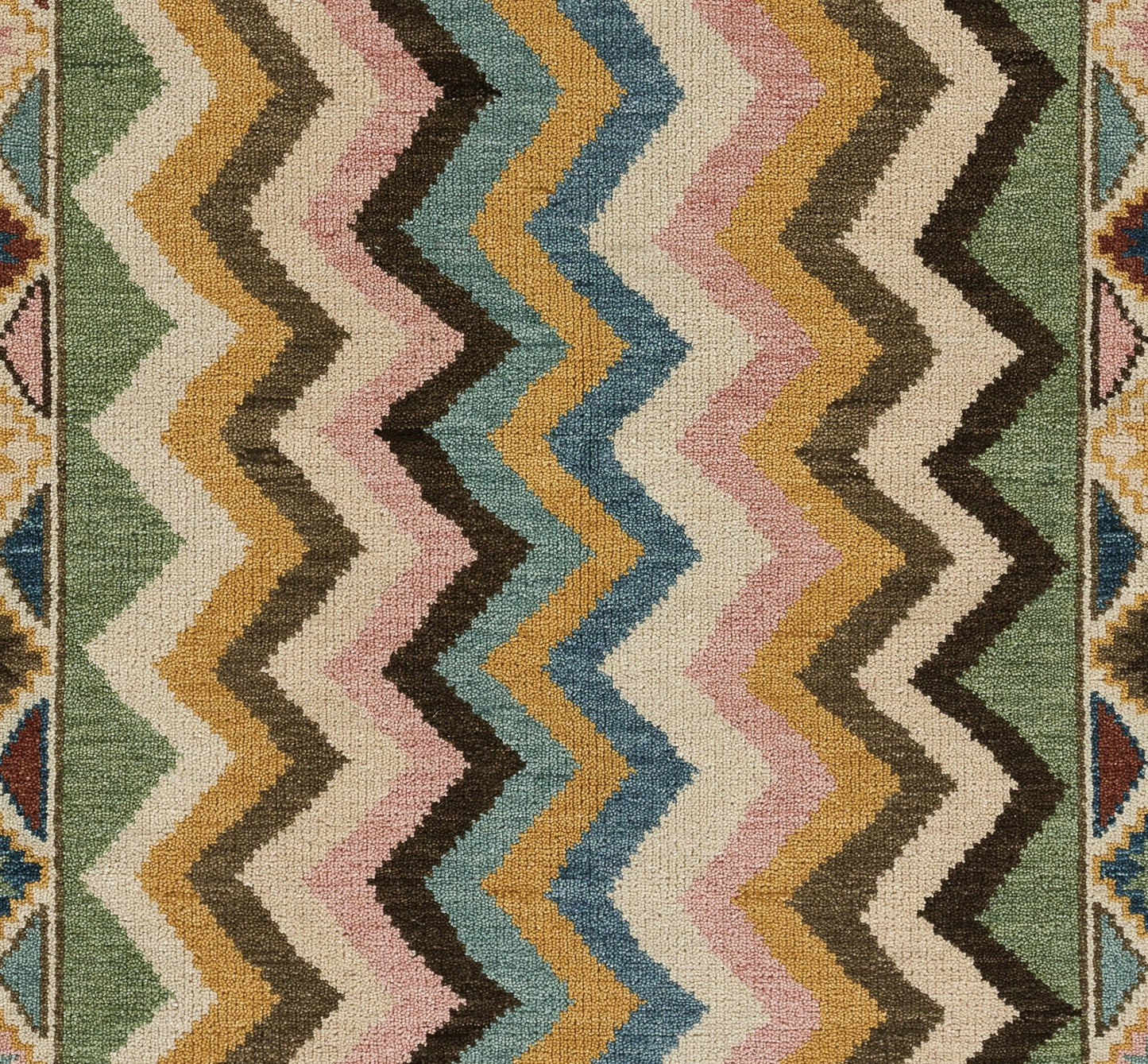 Beige rectangular rug with a narrow multicolor striped kilim border along the top edge.