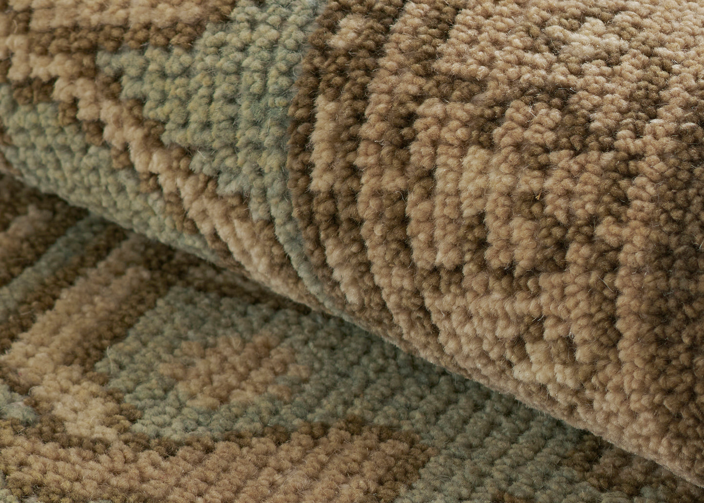 Close-up of a brown-beige and sage green boucle rug with thick loop pile and textured fibers.