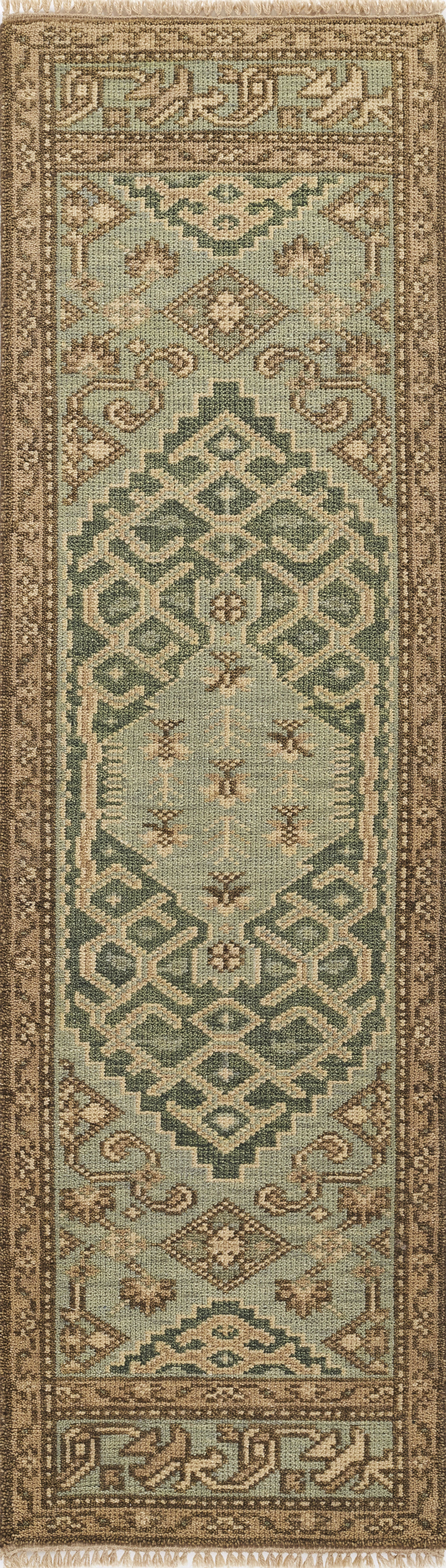 Nomad-style 5' x 8' rug in teal & beige with geometric medallions & ornate brown border.