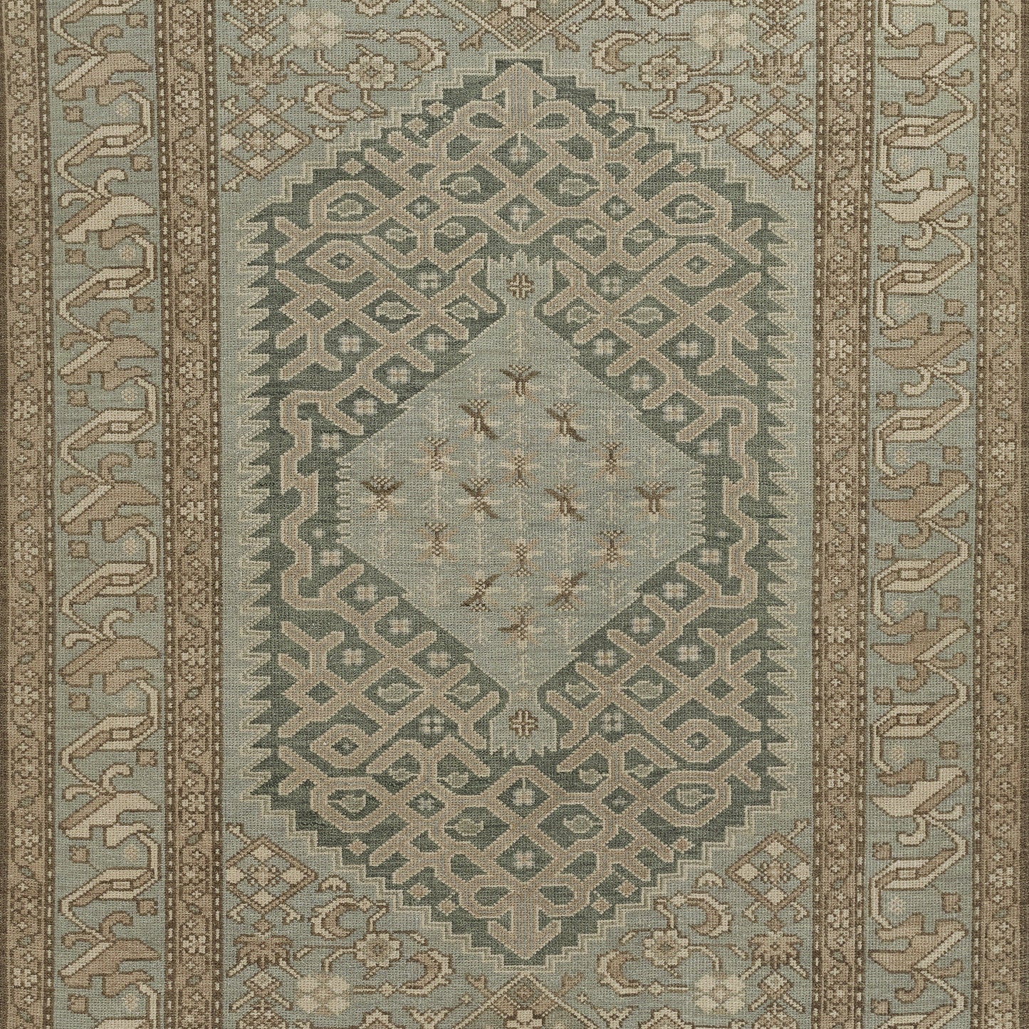 Nomad-style rug in teal and beige with geometric motifs, central diamond medallion and decorative border.