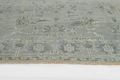 Pale blue nomad-style rug with cream geometric motifs and fringe along edges.