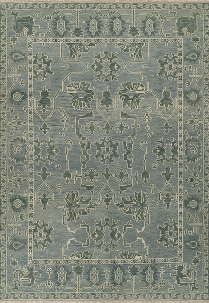 Nomad blue area rug with pale ivory floral medallions and geometric border; distressed antique look, ideal for living room.