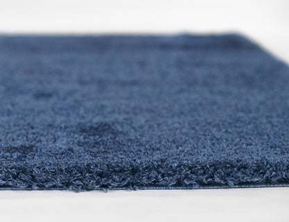 Navy blue shag rug with dense plush pile and finished edge, perfect for living room or bedroom decor.