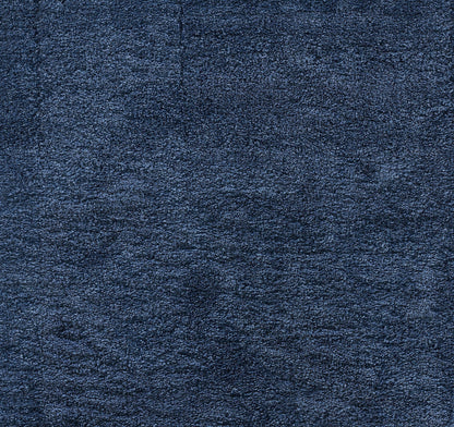 Dark navy blue shag rug close-up showing thick, fluffy fibers.