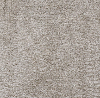 Beige textured carpet close-up with soft loop pile; neutral taupe color, cozy home flooring.