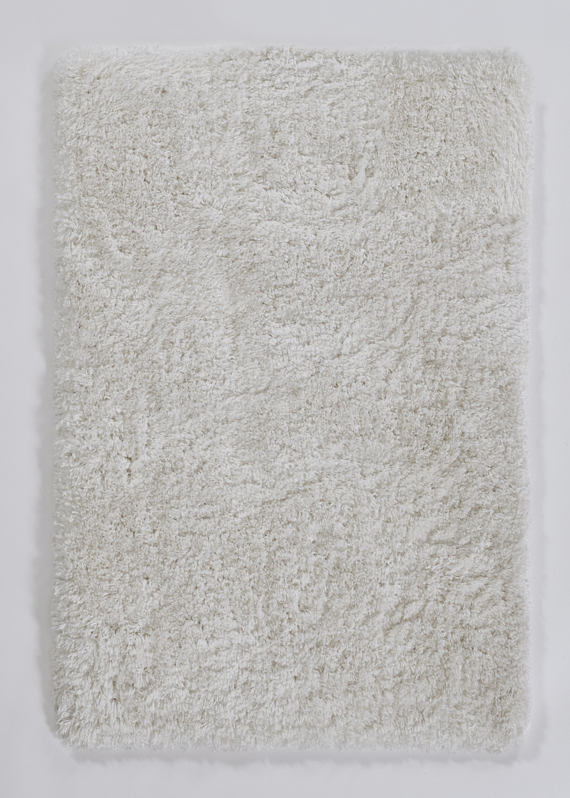 Cream shaggy bath rug with long plush pile; rectangular microfiber mat for bathroom.