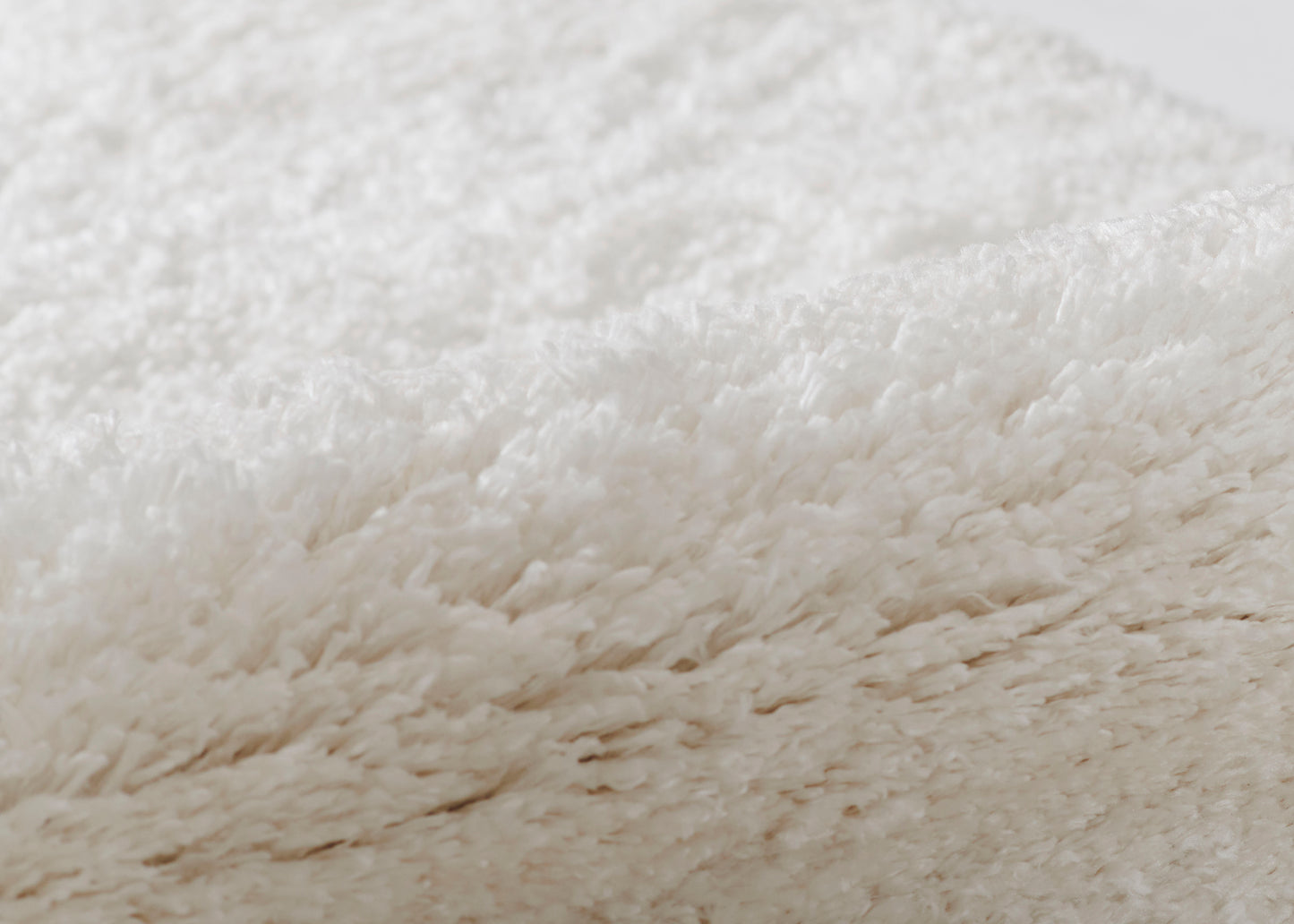 Cream shag area rug with ultra-soft, long plush fibers and cozy fluffy texture.