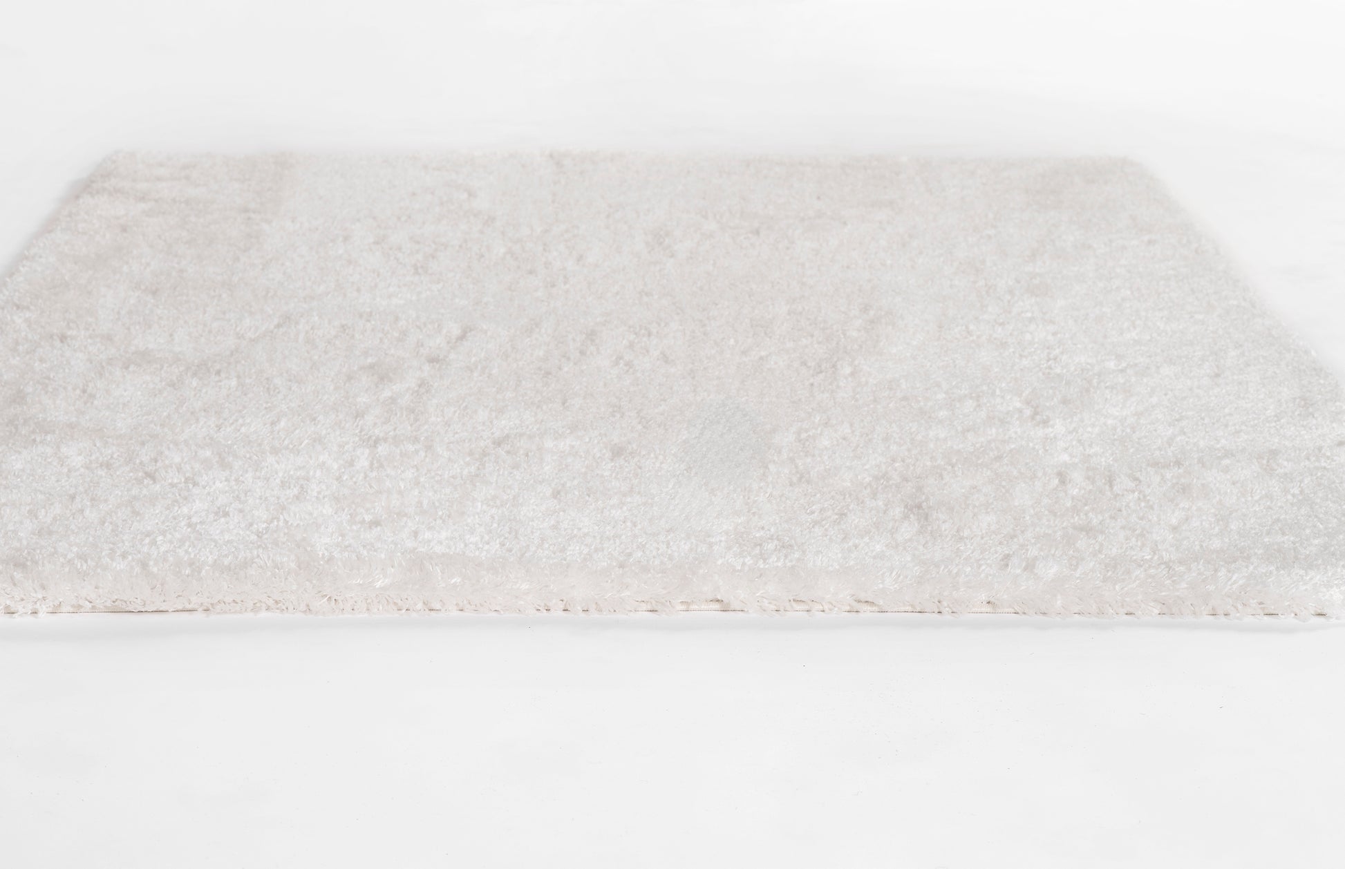 Cream shag rug with plush pile, rectangular beige rug for living room or bedroom.