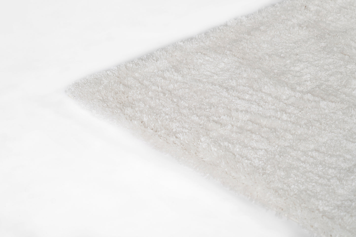 Cream shag rug with fluffy pile on white surface; rectangular, cozy home decor accent.