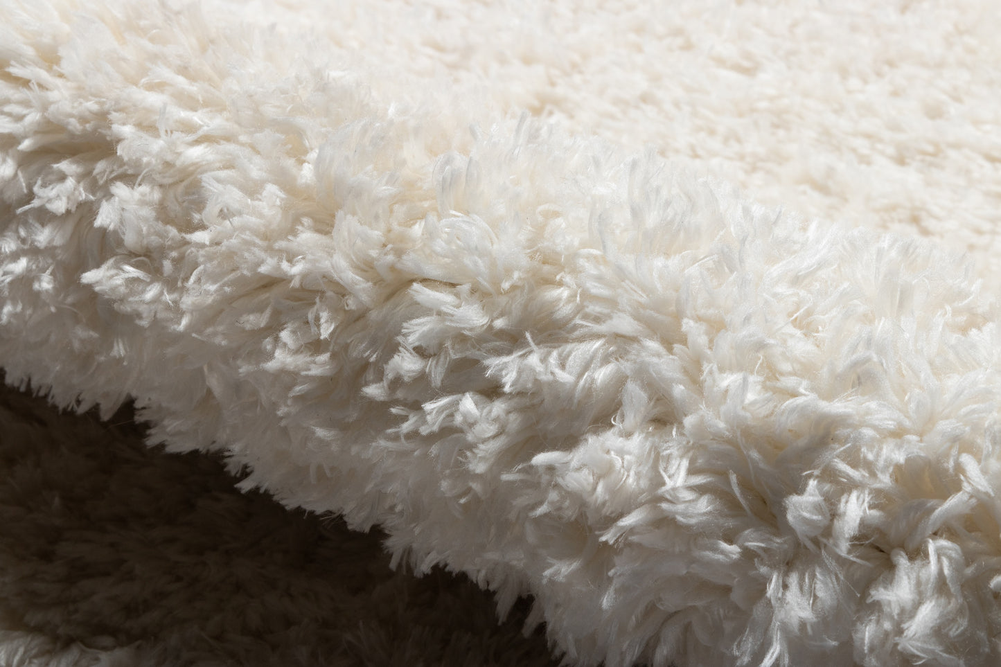 Cream-white shag faux fur rug with long plush fibers, soft cozy decorative throw.