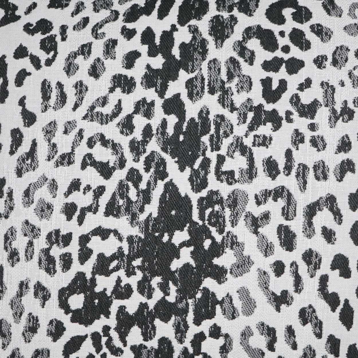 Outdoor pillow with charcoal animal print on a gray background; black irregular spots, 22" x 22