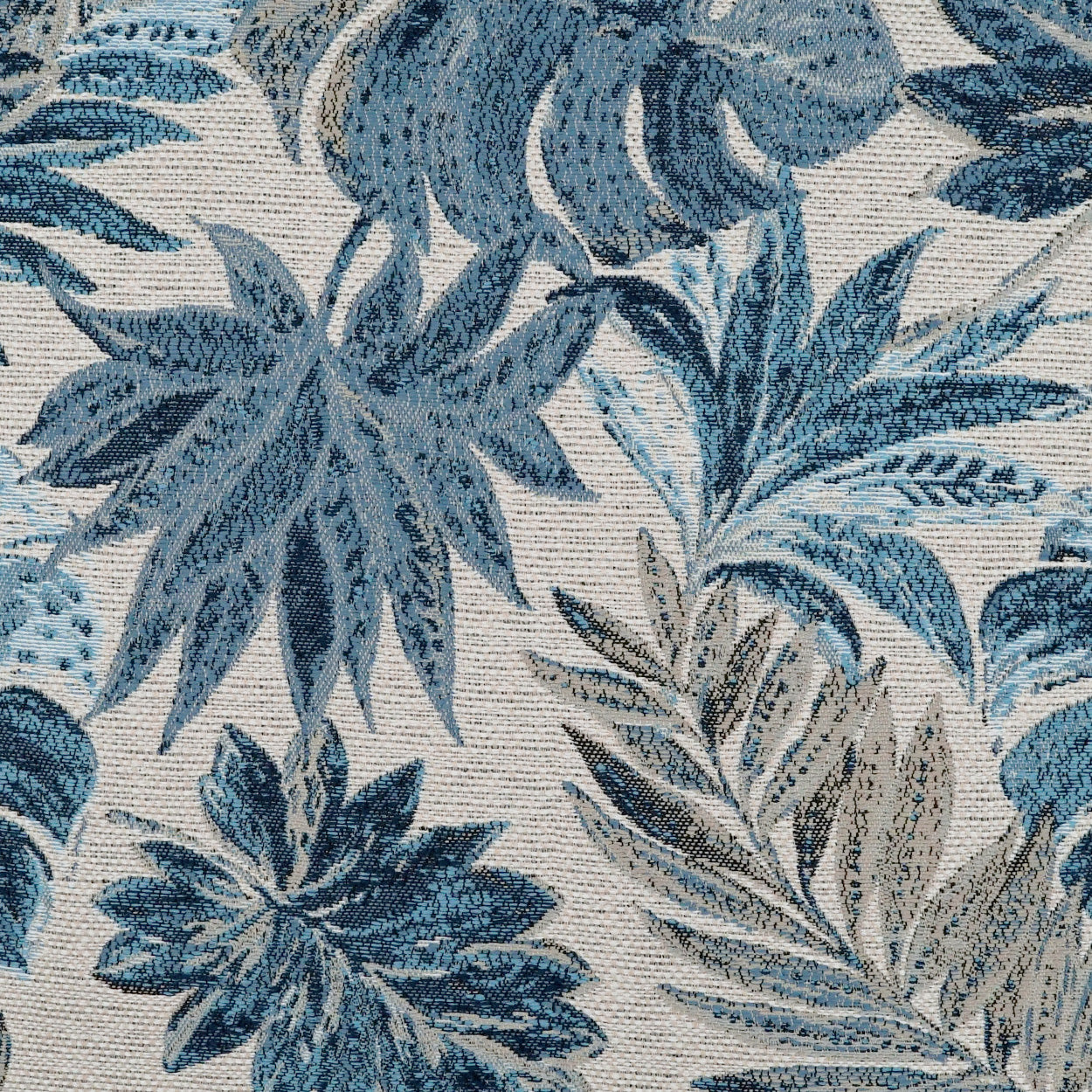 Blue tropical leaf print fabric with beige accents; woven botanical tapestry pattern.