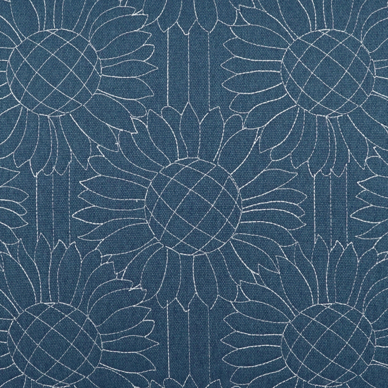 Blue fabric with repeating white sunflower motifs; circular centers with crosshatched patterns and petal outlines.