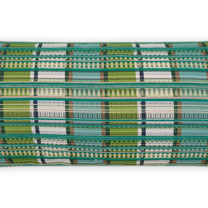 Rolled woven plaid fabric in greens, teals, white and blue.