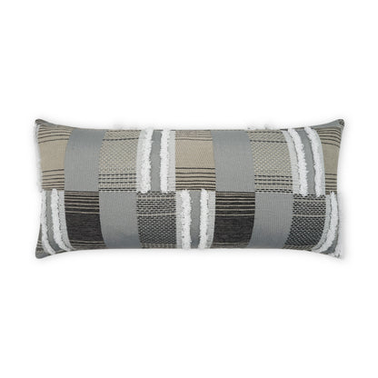 Rectangular lumbar pillow in neutral patchwork stripes; beige, gray, taupe and black textured woven fabric with fringe edges.