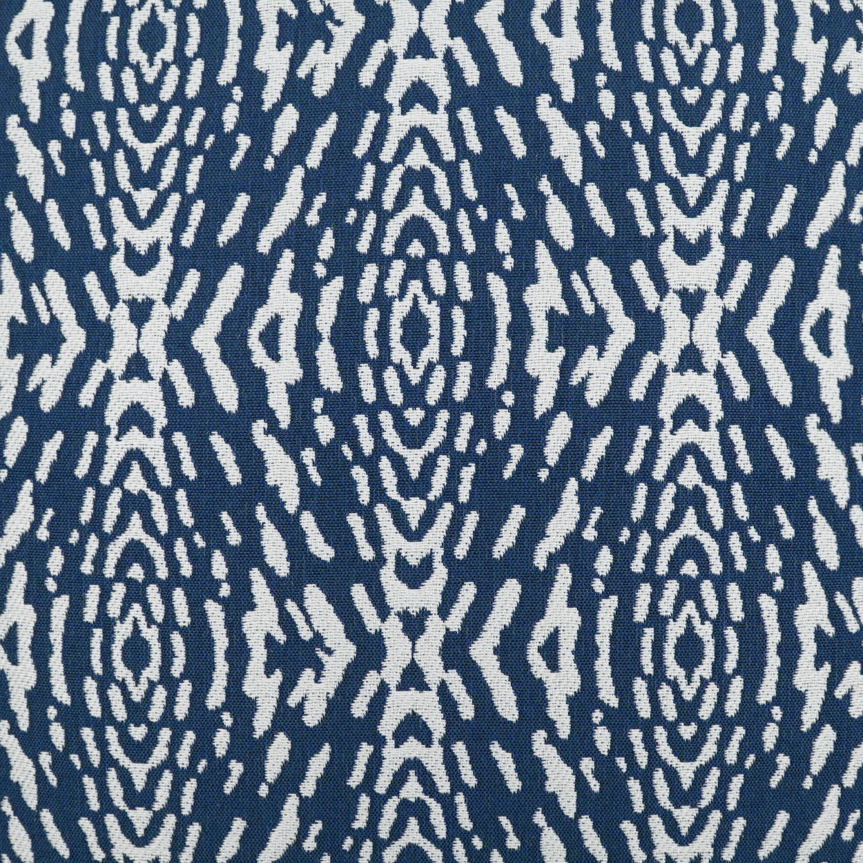 Navy blue pillow with ivory Ikat-style geometric pattern; outdoor 22" x 22" pillow.