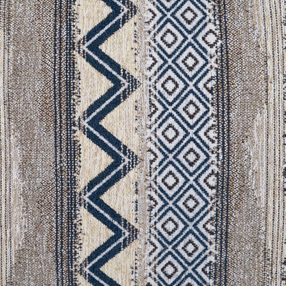 Textured woven rug in beige, tan and navy with zigzag stripe and diamond patterns; boho geometric style for living spaces.