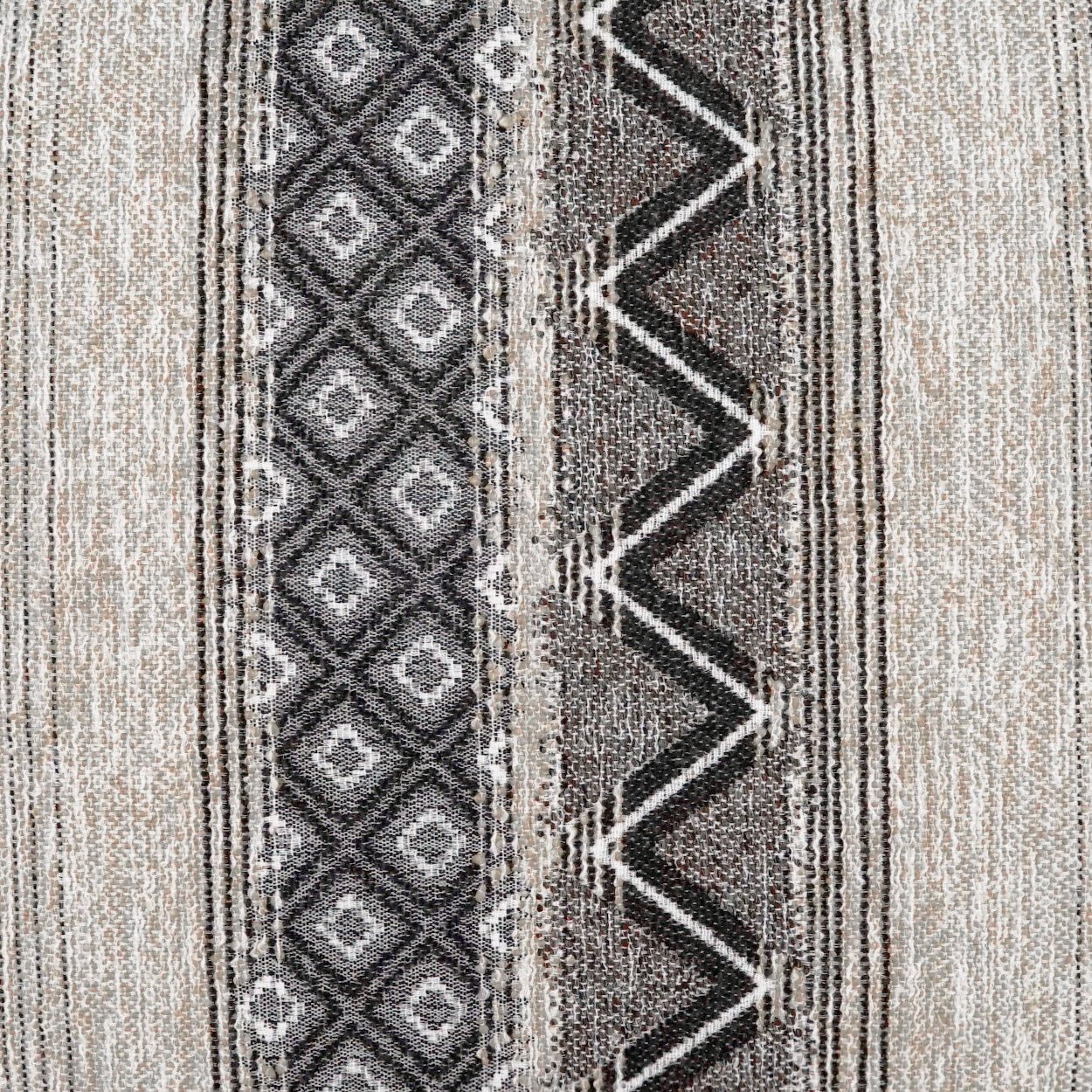 Beige and gray woven rug featuring a left diamond stripe and a right bold black zigzag band.