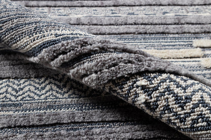 Blue-gray shag rug with ivory & navy chevron pattern, plush pile, folded edge.