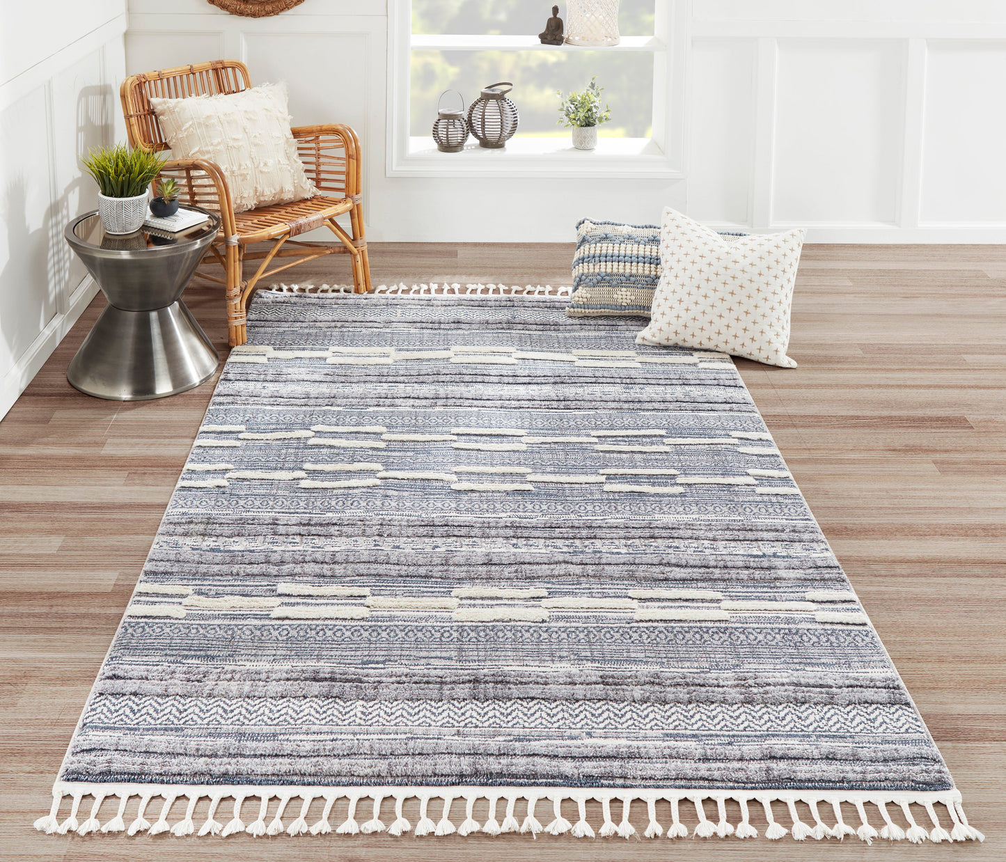 Blue-grey striped woven area rug with white fringe tassels; rectangular rug adds cozy coastal style to the living room.