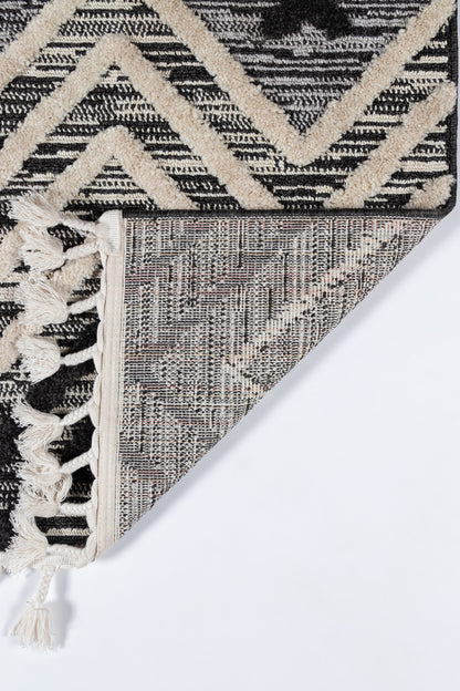 Black and ivory geometric rug with chevron zigzag, woven texture and fringe tassels.