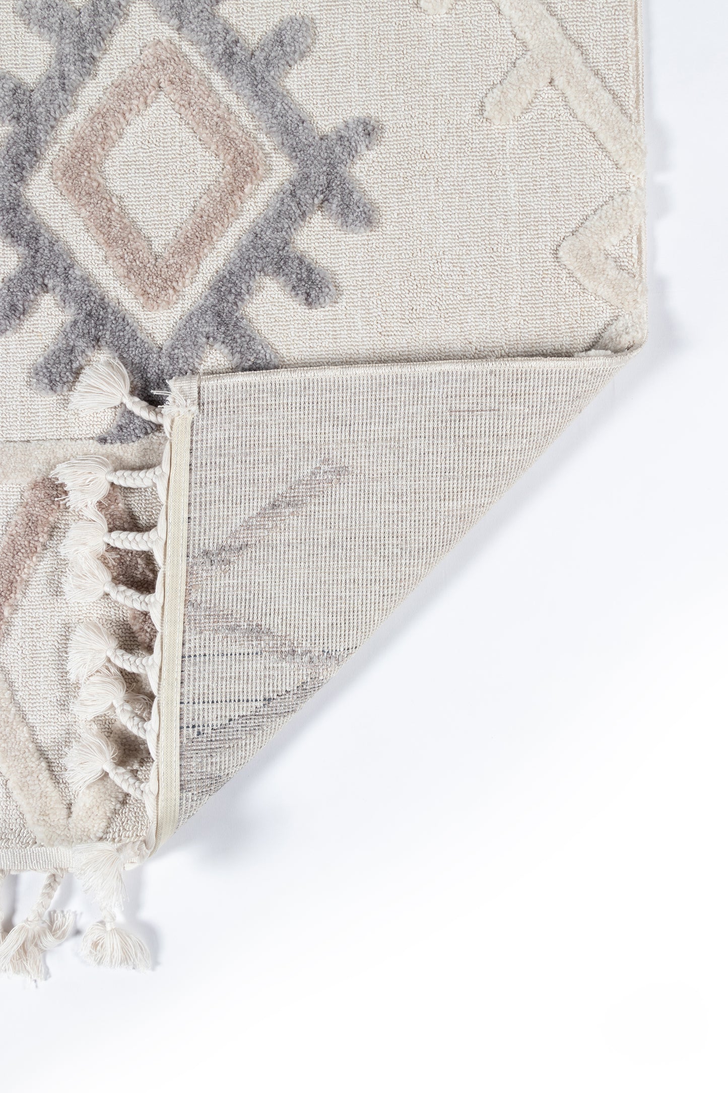 Rectangular woven rug in beige and ivory with gray geometric diamond pattern and tassel fringe along edge.