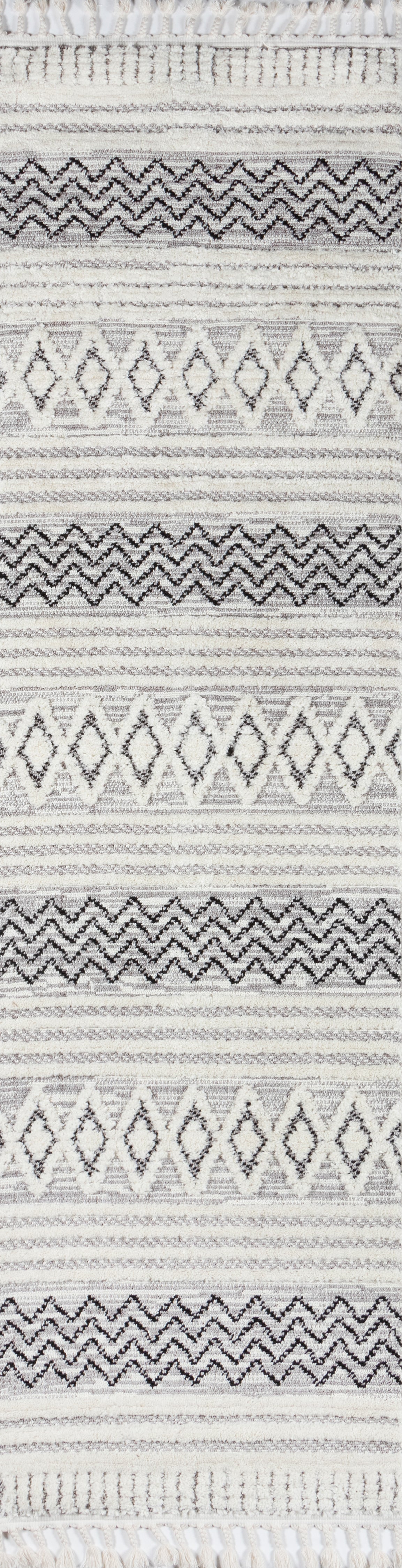 Grey and ivory woven rug with diamond and chevron motifs, textured weave and fringed edges.