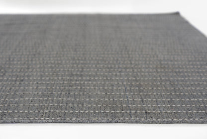 Dark gray woven rug with a light gray dotted grid pattern; rectangular, modern textile.