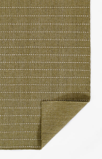Olive green woven rug with white dashed stripes and a folded corner.