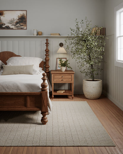 Olive natural area rug in a room setting with wooden furniture.
