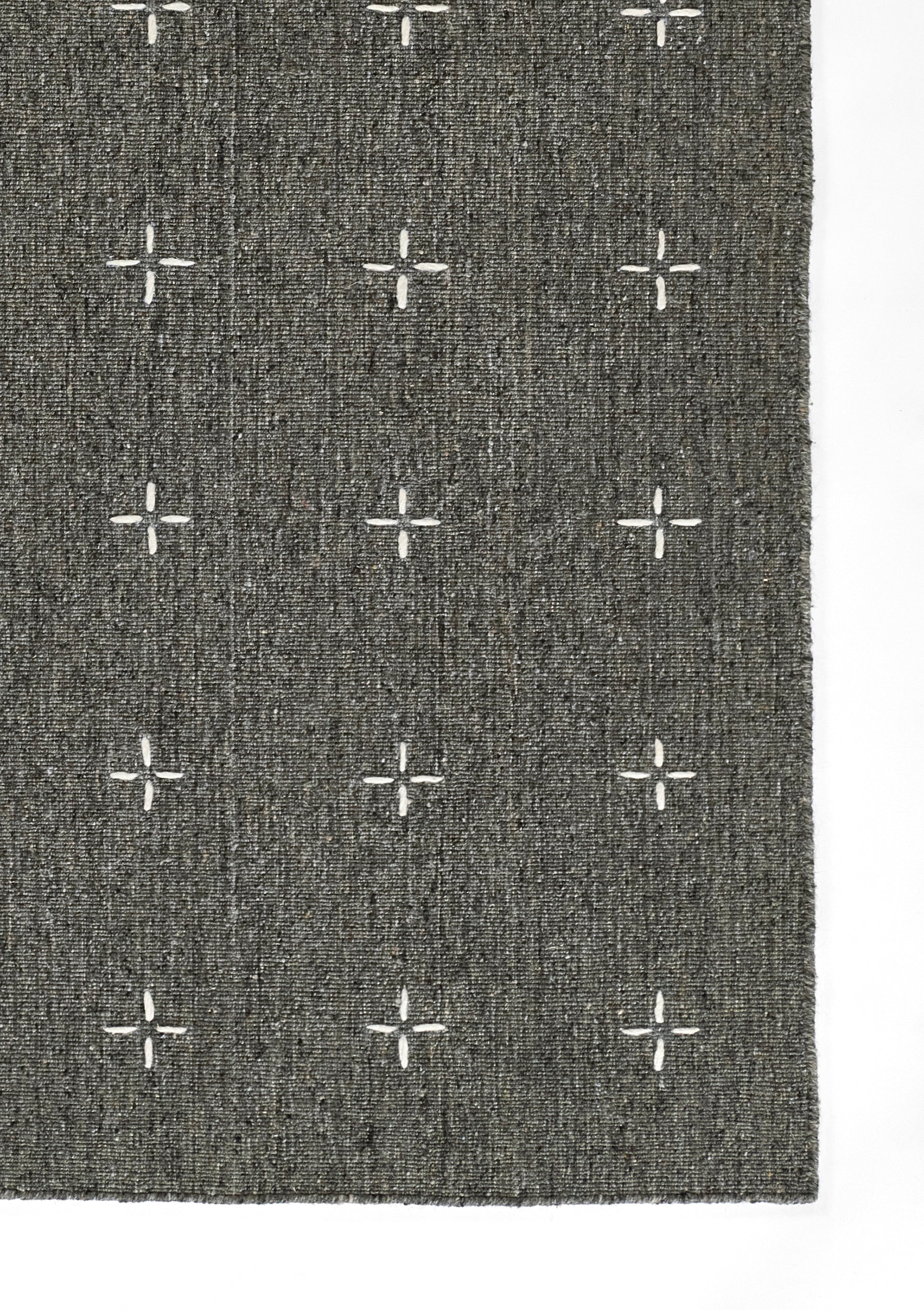 Rectangular charcoal gray woven rug with white cross motifs in a grid; modern geometric style, for living room or hallway.
