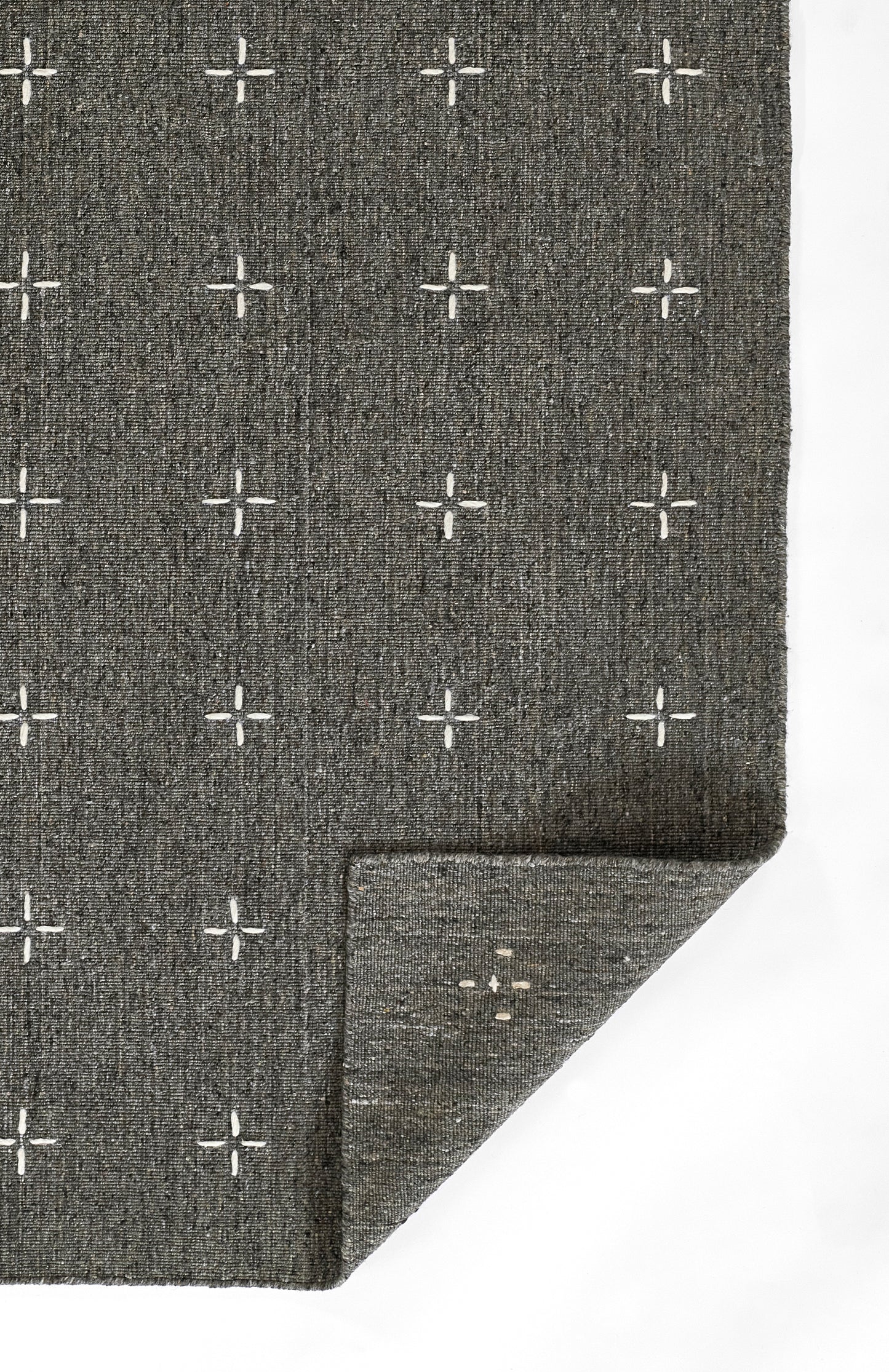Charcoal gray woven rug with white plus-sign grid pattern; textured fabric with folded corner.