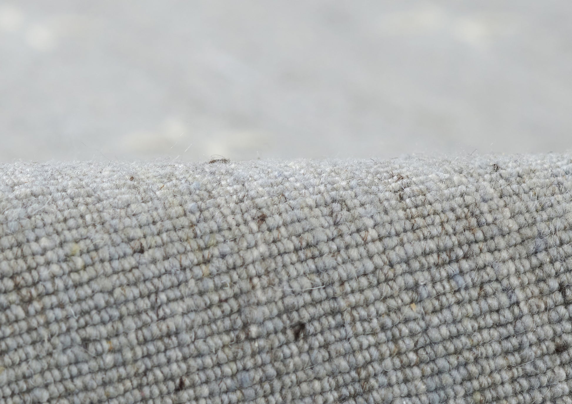 Close-up of gray woven rug runner with a tiny loop texture.