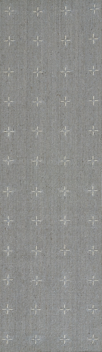 Grey textured rug with a subtle repeating pattern of white cross-stitch motifs.