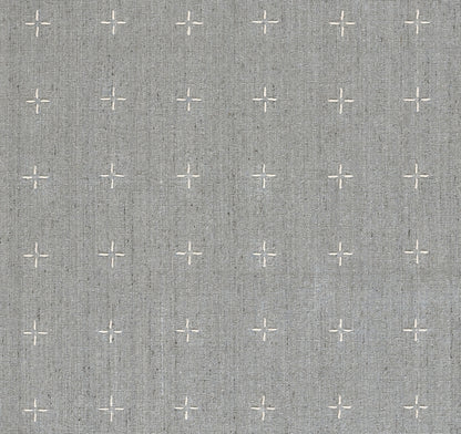 Olive rug with small white cross motifs; linen-look texture.