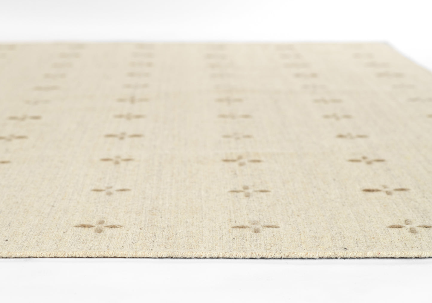Cream-colored woven rug with textured fibers and small cross motifs in parallel rows.