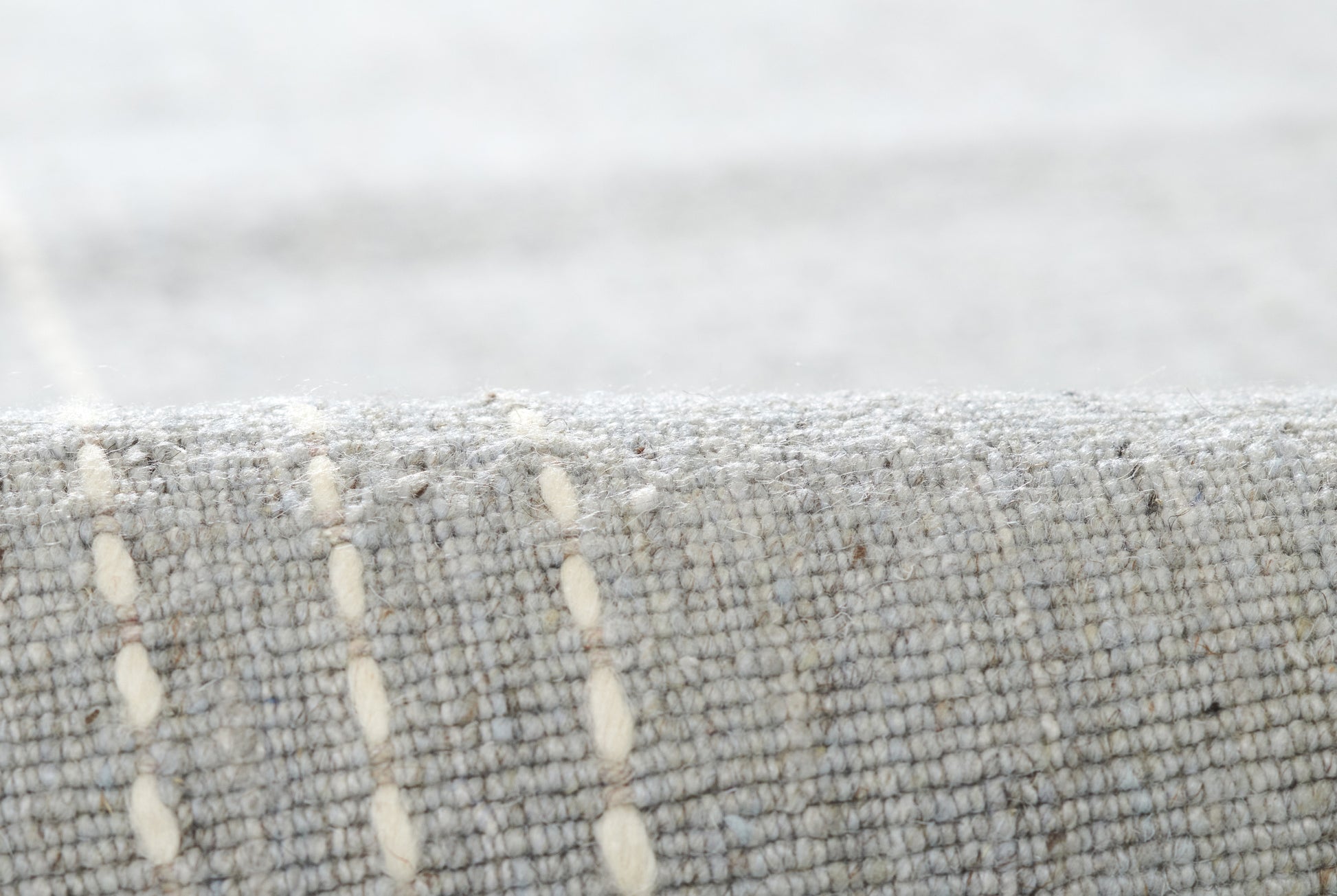 Rolled gray woven runner rug with cream vertical dashed lines; textured, modern home decor.