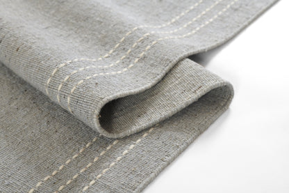 Grey linen-look kitchen towel with white double-stitch seams, folded to show soft textured fabric.
