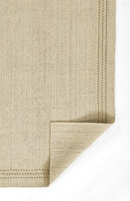 Beige natural fiber flat-weave rug with subtle vertical texture and double dotted border, folded corner.