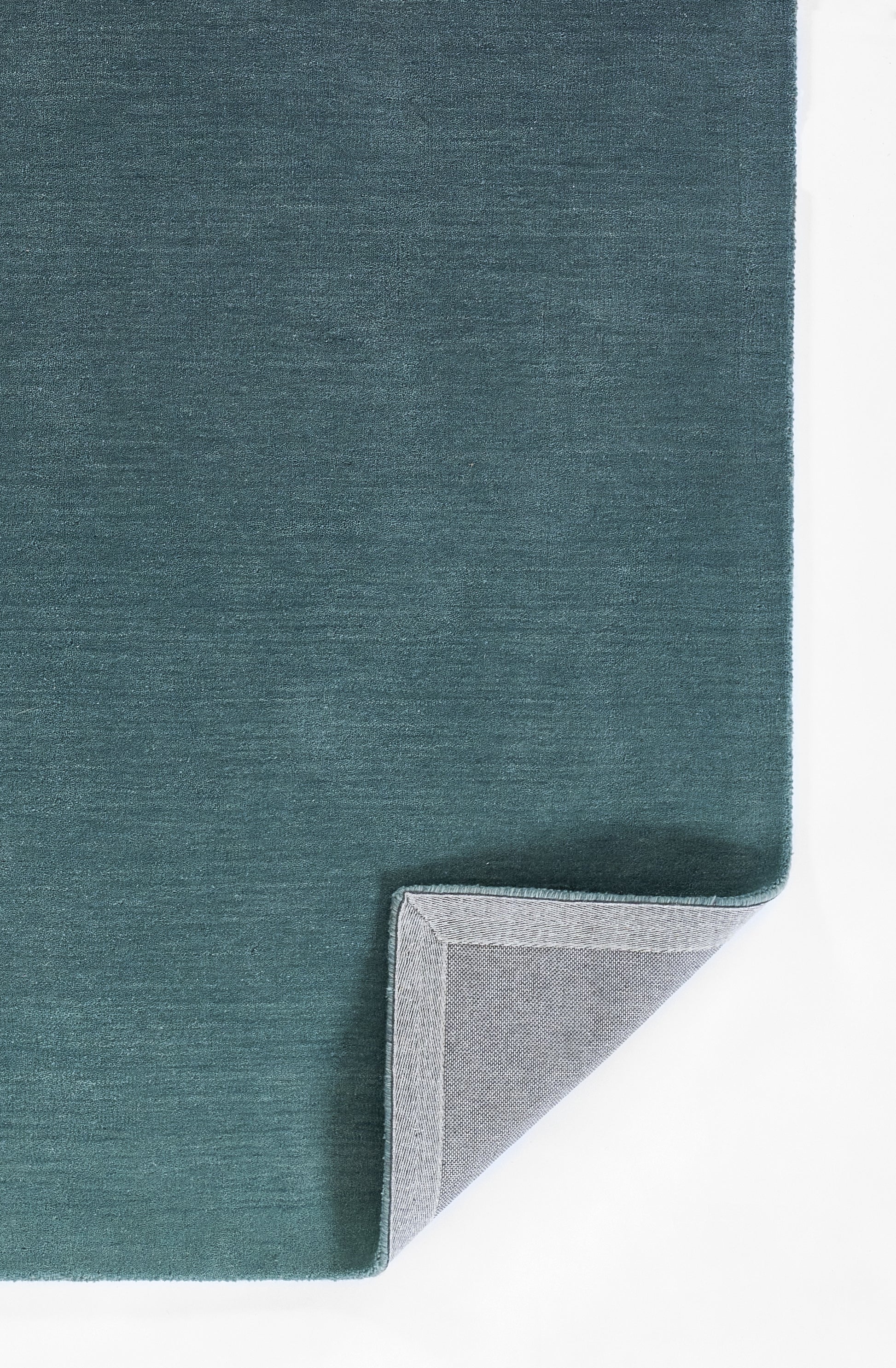 Teal ombre rug with soft, textured surface; folded corner shows gray backing.