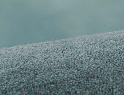 Blue ombre boucle rug closeup with dense plush pile; cozy modern decor.
