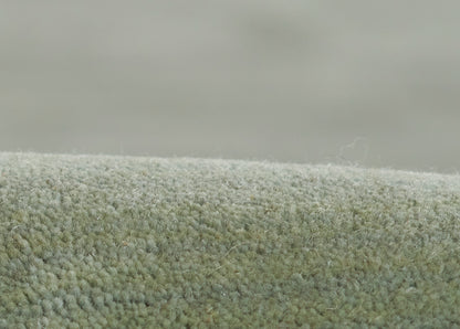 Ombre green rug with plush tufted pile in light sage to olive tones, cozy living room decor.