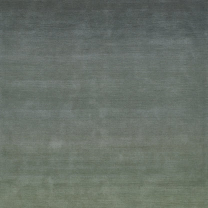 An ombre green rug fades from dark blue-green at the top to olive at the bottom; textured, rectangular, modern decor piece.
