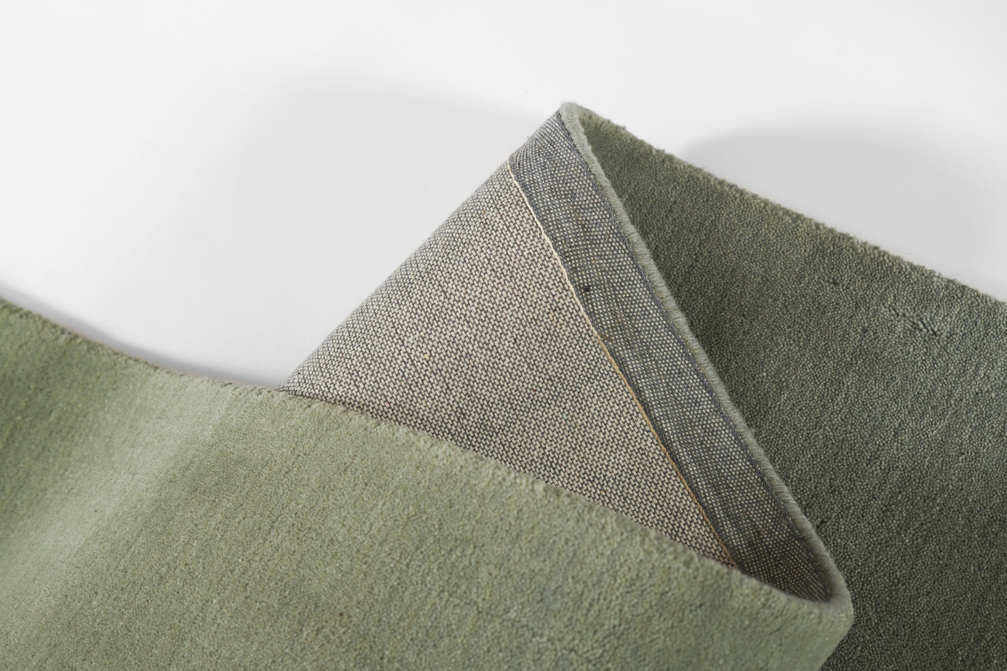Olive to sage green ombre rug with soft plush pile and woven back edge; modern, cozy floor decor.