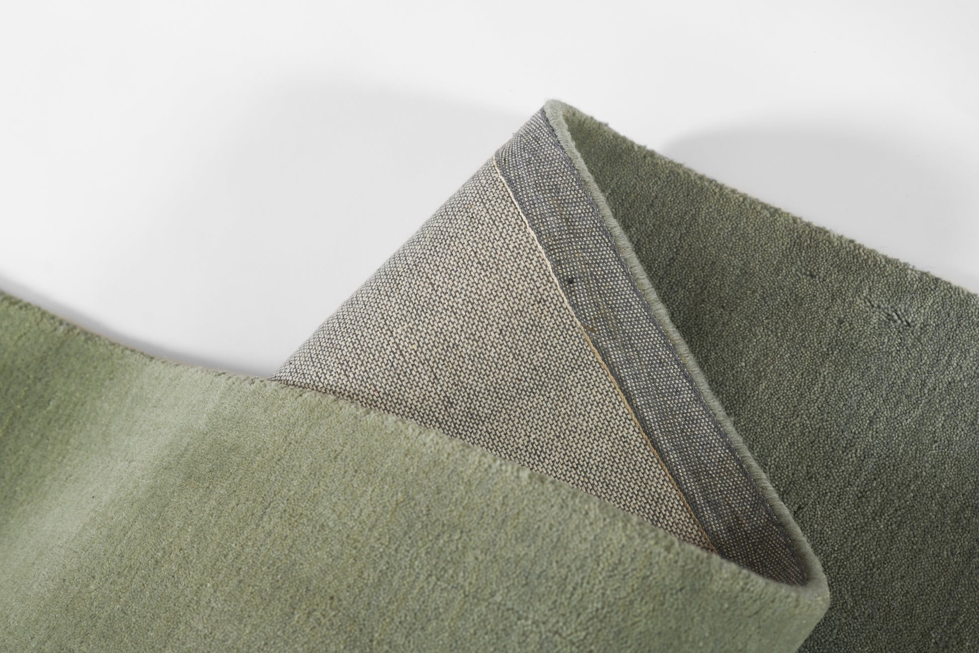 Olive to sage green ombre rug with soft plush pile and woven back edge; modern, cozy floor decor.