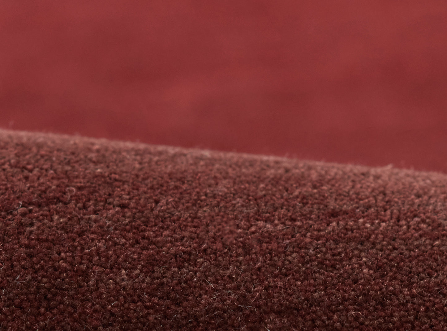 Close-up of burgundy ombre boucle rug; soft fuzzy texture with a deep red gradient.