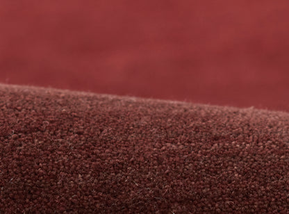 Close-up of burgundy ombre boucle rug; soft fuzzy texture with a deep red gradient.