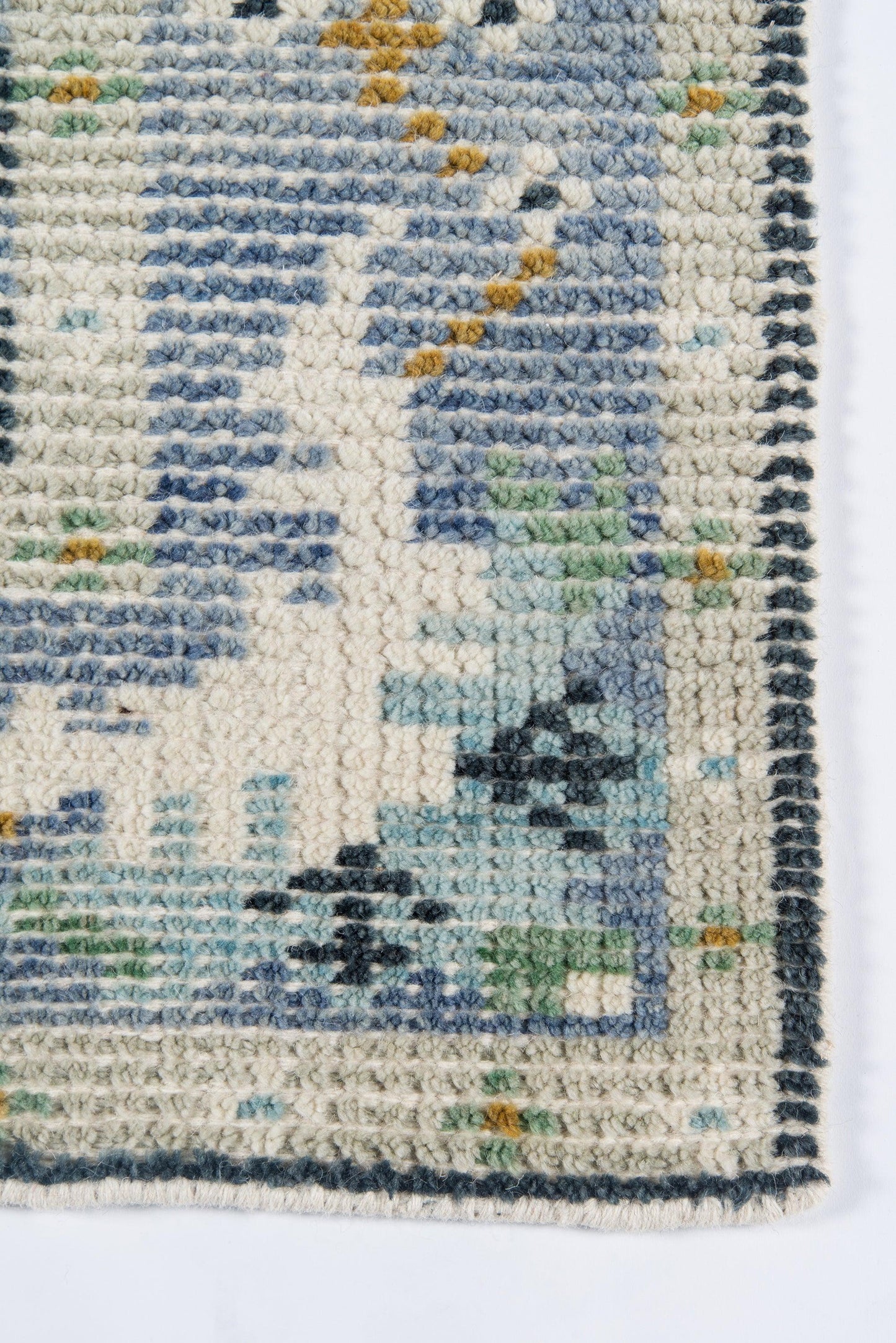 Handwoven wool rug with cream border and dark teal edge, blue abstract motif; cozy decorative floor covering.